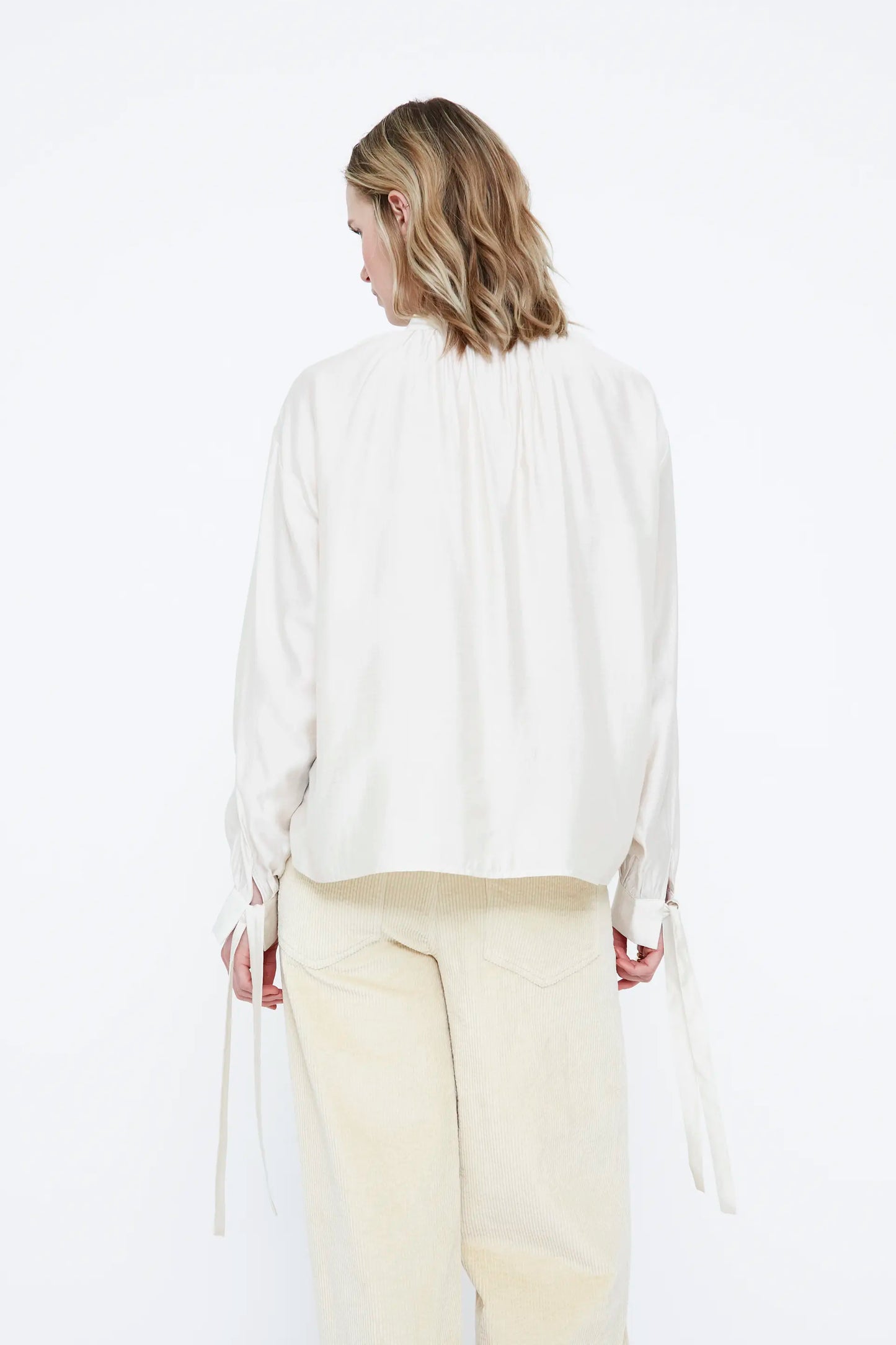 Camisa de saten blanco roto con detalle lazado